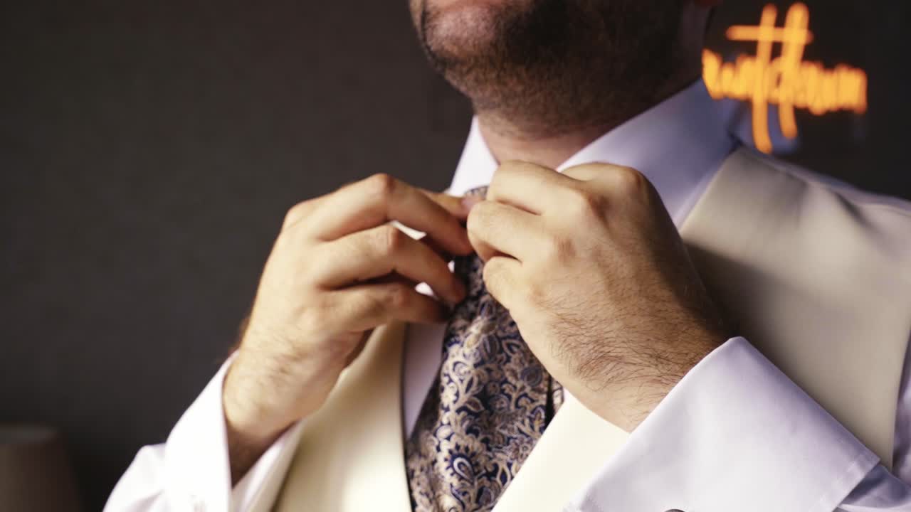 boy dressed in white fixing his tie that was poorly arranged