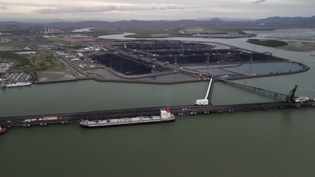 Aerial flyover of coal terminal pier and ships at Gladstone, Australia