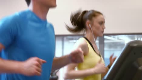 Pareja-Corriendo-En-Cintas-De-Correr-En-El-Gimnasio