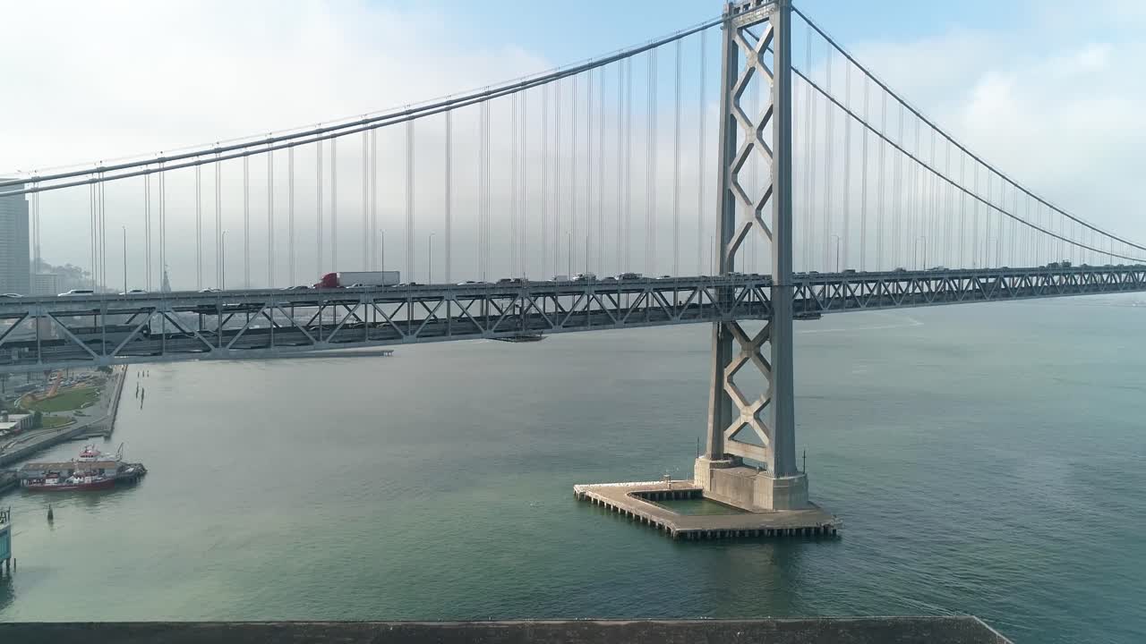 도시를 배경으로 샌프란시스코-오클랜드 베이 브릿지에서 이동하는 차량의 공중 촬영