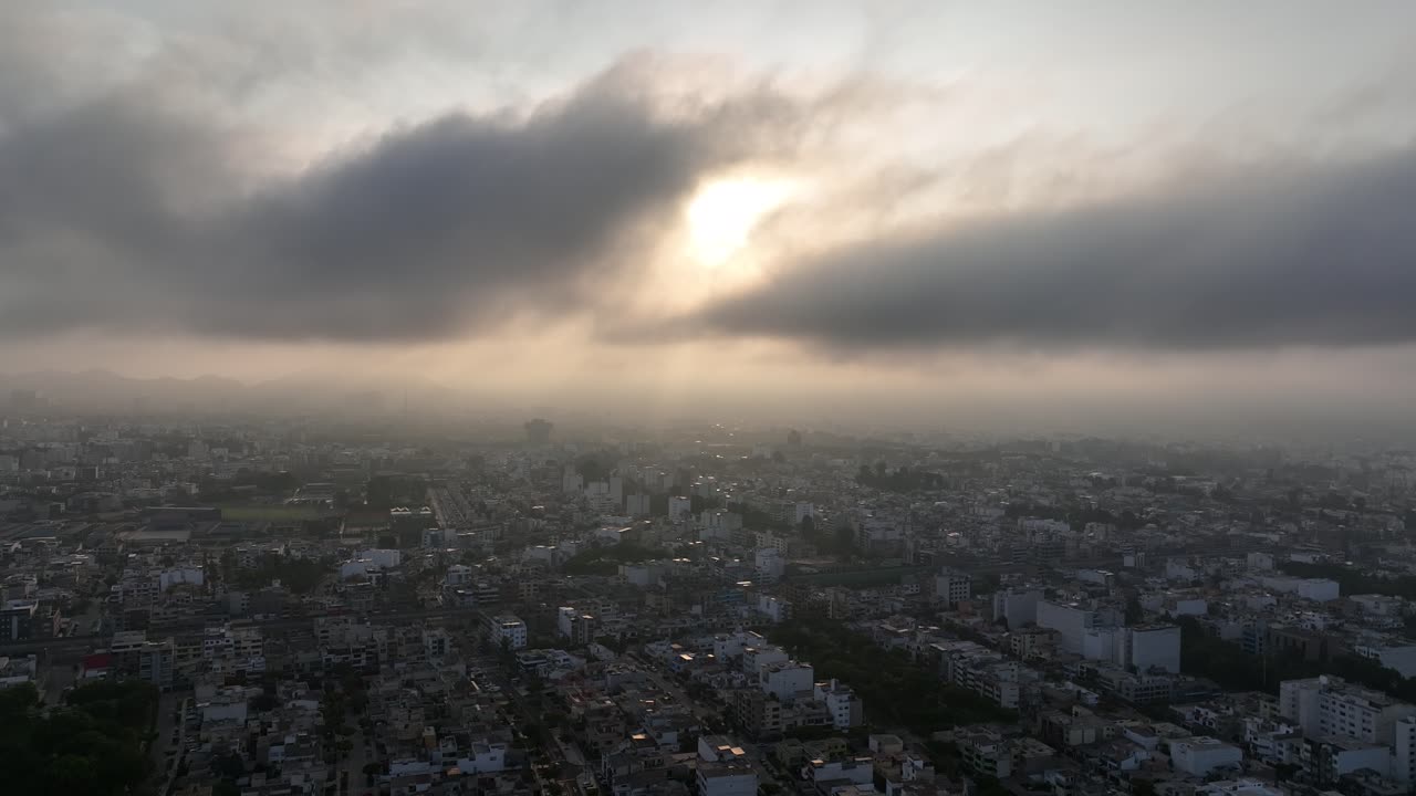 drone elevándose alto desde la zona residencial de lima sobre nubes y luz solar, perú