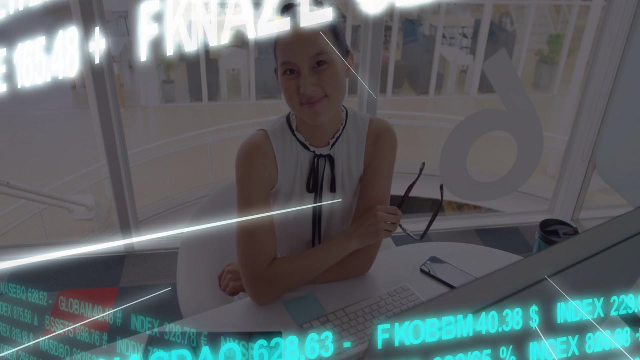 Writing Asian woman with ribbon tie at desk, holding green pen and glasses amid financial ticker