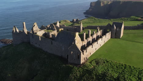 hermosa toma de drones de la roca con la vista completa del castillo medieval escocés dunnottar cerca del mar