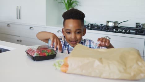 Feliz-Niño-Afroamericano-Desempacando-Comestibles-En-La-Cocina
