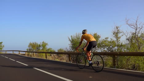 amid the tranquility of the morning, a man takes his road bike for a spin on a deserted road, immersing himself in outdoor exercise. the slow-motion capture accentuates the essence of extreme sports