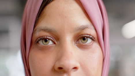 retrato de ojos felices de una mujer de negocios de dos razas en hijab en la oficina, en cámara lenta