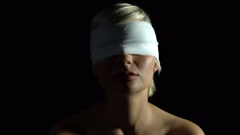 Crying-blind-folded-woman-with-tears-on-her-chin-over-black-background