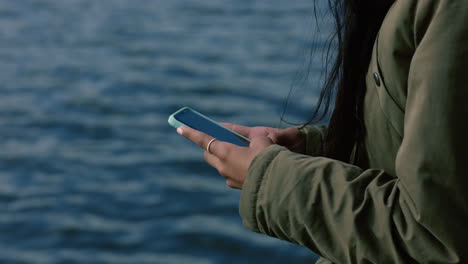 close-up-woman-hands-using-smartphone-texting-sending-messages-chatting-online-social-media-sharing-digital-communication-on-mobile-phone-in-seaside