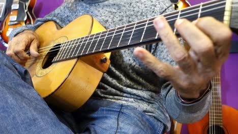 guitarra acústica siendo tocada con los dedos