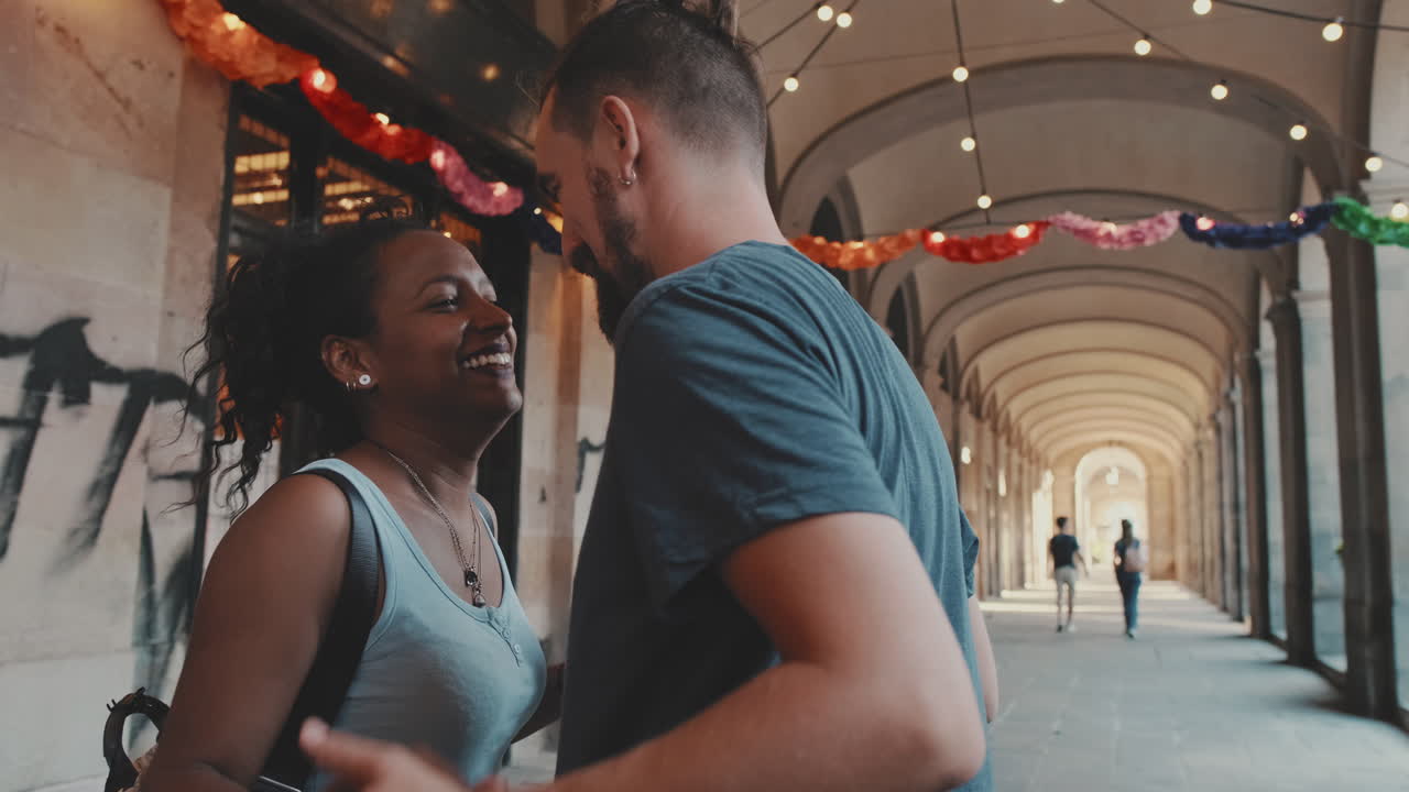 A couple celebrating love and happiness under a rainbow garland