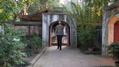 Male-model-strolling-through-archway-into-garden-photoshoot-location