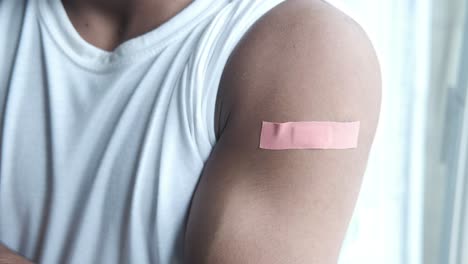 hombre con vendaje en el brazo después de la inyección de la vacuna