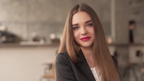 Retrato-De-Una-Hermosa-Niña-Sonriente-Con-Cabello-Castaño-Largo-Y-Lápiz-Labial-Rojo-Sentada-En-Una-Cafetería