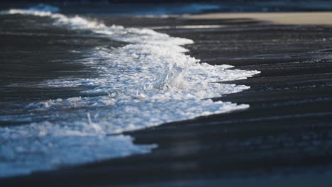 waves roll slowly on the shallows of the sandy beach in ersfjord