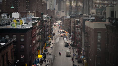 Looking-down-a-busy-city-street-as-pedestrians-and-cars-commute