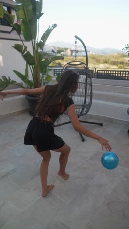 woman playing with a ball on a balcony