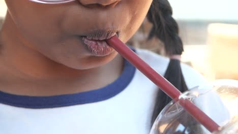 child drinking from a straw