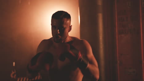 shirtless boxer man looking directly at the camera and doing boxing moves 1