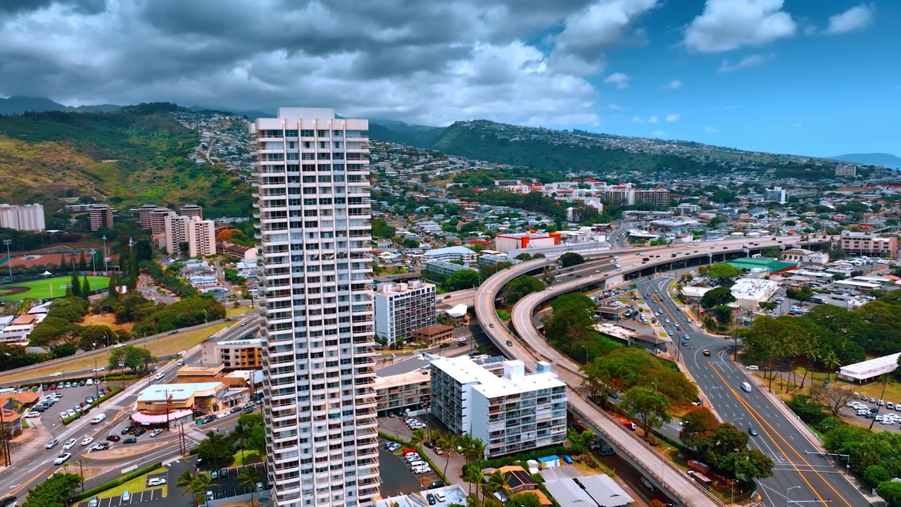 Edificio a più piani che spicca nel panorama di Honolulu, Hawaii, USA. Spettacolare cielo nuvoloso sopra la città. Veduta aerea