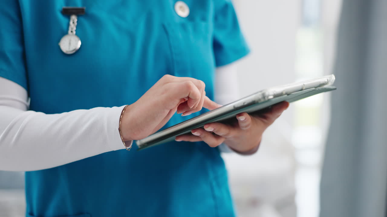 Professionista sanitario in divisa medica che usa un tablet digitale.