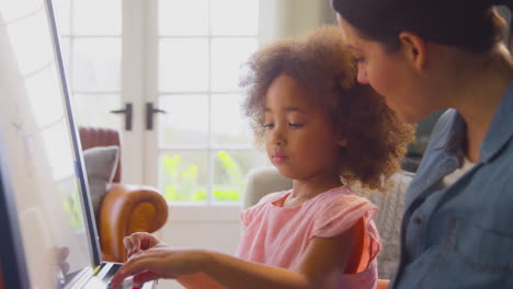 mother and daughter having fun drawing picture on whiteboard at home together