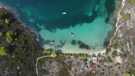 Overhead-Drohne-Clip-Einer-Kleinen-Tropischen-Inselbucht-Mit-Kristallblauem-Wasser-Und-Luxuriösen-Booten-In-Der-Gegend-Von-Vourvourou,-In-Nordgriechenland-Chalkidiki-In-4k