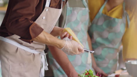 chef grating cheese on salad during cooking class