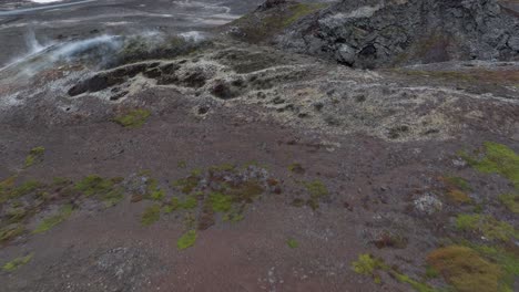 a breathtaking shot captures an unidentified volcano near myvatn at reykjahlid in iceland, displaying a mesmerizing landscape of red and gray rocks