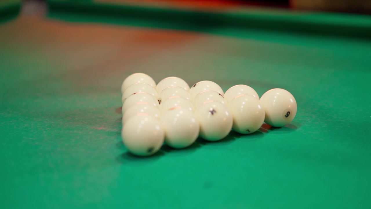 Close-up of Hands Racking Billiard Balls on Green Table