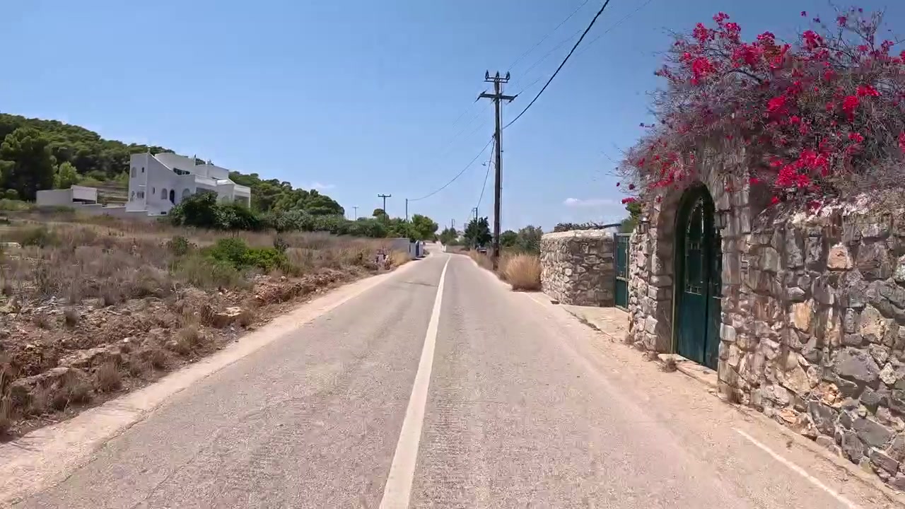 Filmato POV emozionante da uno scooter che percorre una strada panoramica di campagna su una splendida isola greca, catturando la libertà e il fascino della vita isolana nel Mar Mediterraneo, Grecia