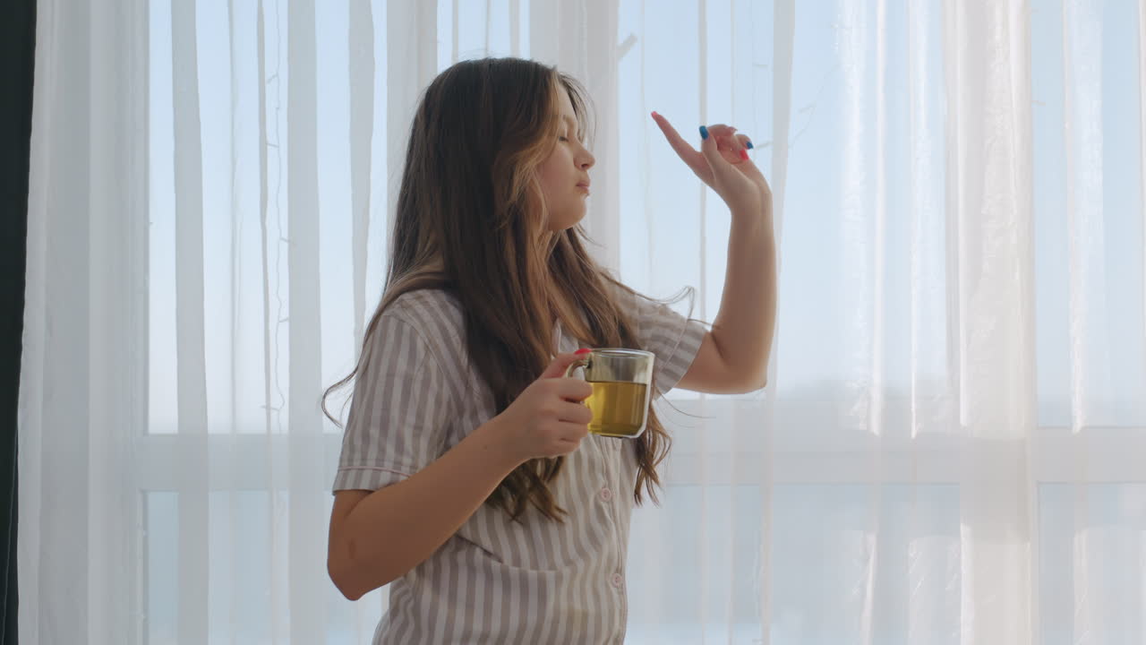 Lady With Flowing Hair Dancing Near Window, Woman Wearing Striped Shirt Moving Gracefully By Light Curtain, Woman With Flowing Hair And Striped Attire Dancing Joyfully Near Window Light