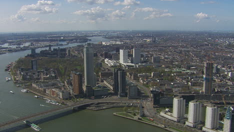 Aerial-establishing-shot-of-downtown-Rotterdam-during-the-day-with-multiple-bridges