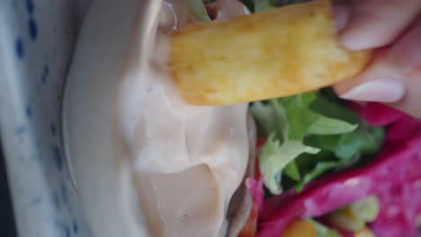 dipping fries in sauce with salad