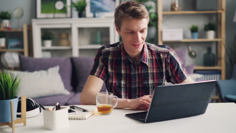 hombre trabajando en una computadora portátil en casa
