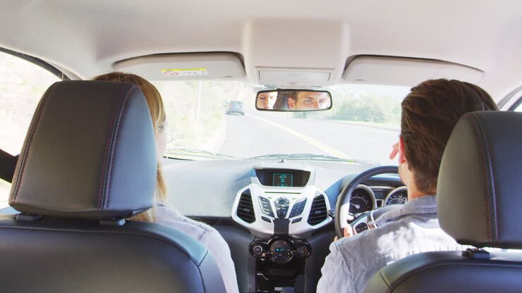 Giovane coppia in viaggio in auto che guarda avanti