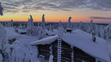 Cabañas-De-Madera-En-Medio-De-Un-Bosque-Helado,-Oscuridad-ártica-En-Laponia---Vista-Aérea