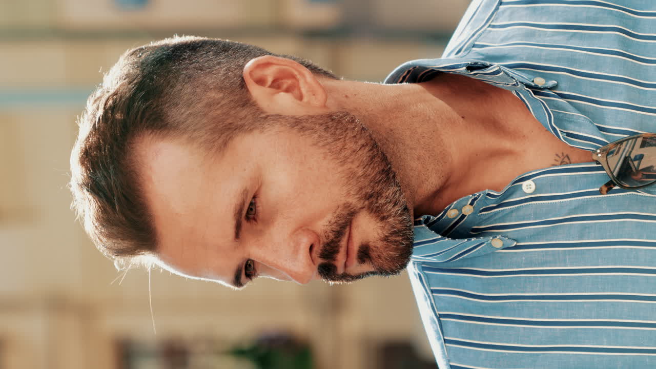 hombre con una camisa a rayas azules, mirando hacia abajo