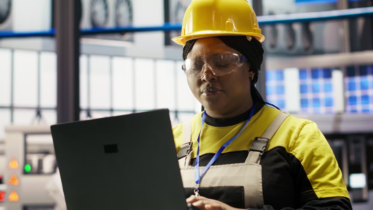 Vertical video Solar panels factory engineer analyzes performance data with laptop