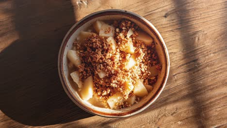 un delicioso cuenco de manzana casera desmoronada con la luz del sol