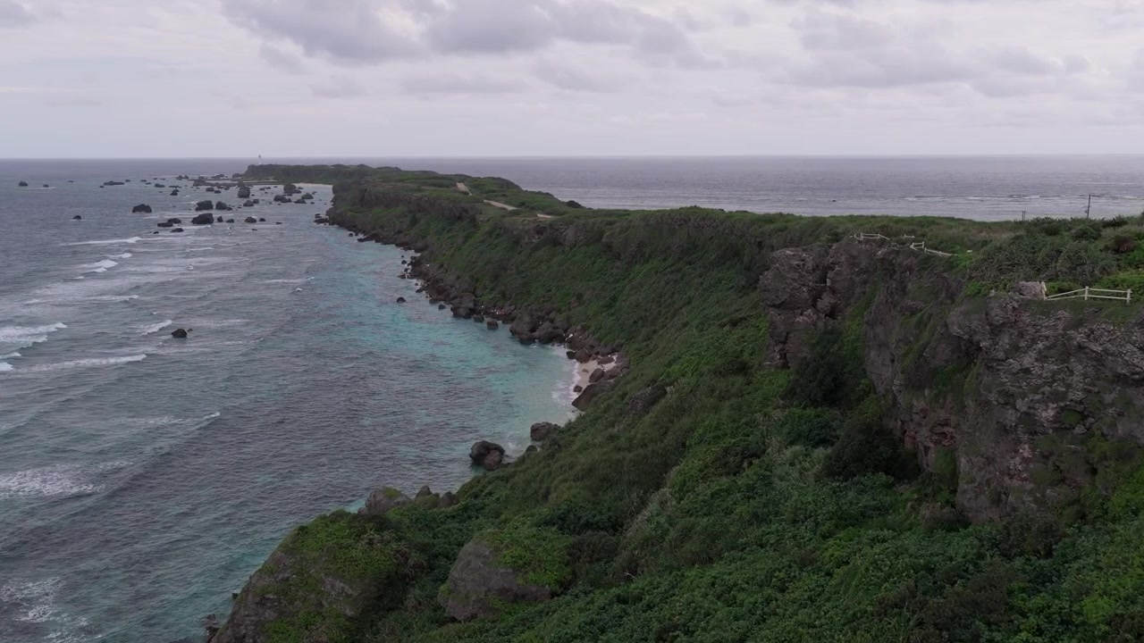Vaakasuuntainen ilmakuva liikkuu eteenpäin dramaattisten kallioiden rinnalla lähellä Hennasakin majakkaa, Boran kalasatamaa ja Maibahin rantaa, Miyakojima, Okinawa, Japani.