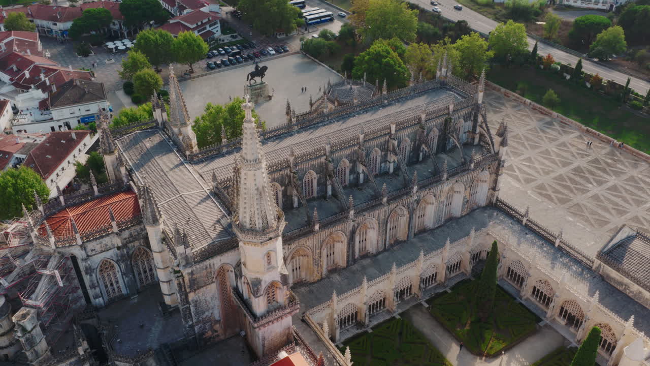 Mosteiro da Batalha aerial wide shot, gentle forward drift with village and hills rolling behind the monument