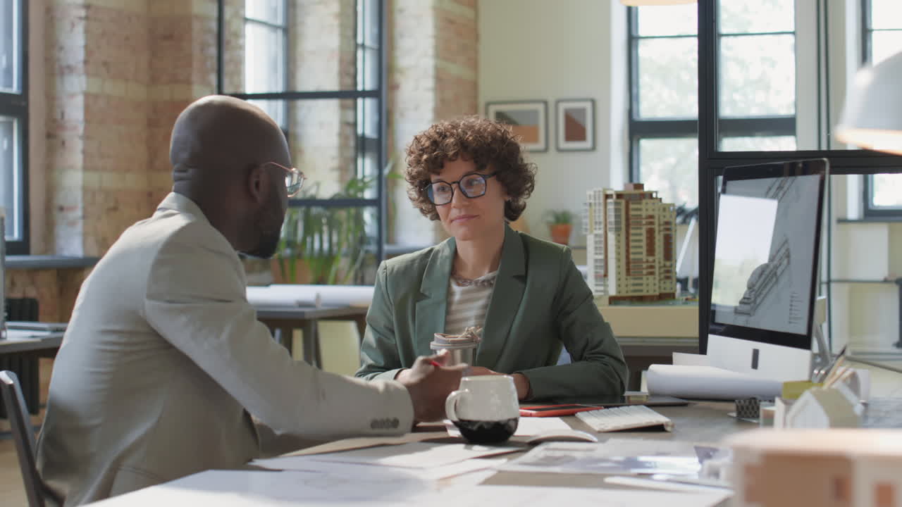 Architects Collaborating and Discussing Project Designs in an Office
