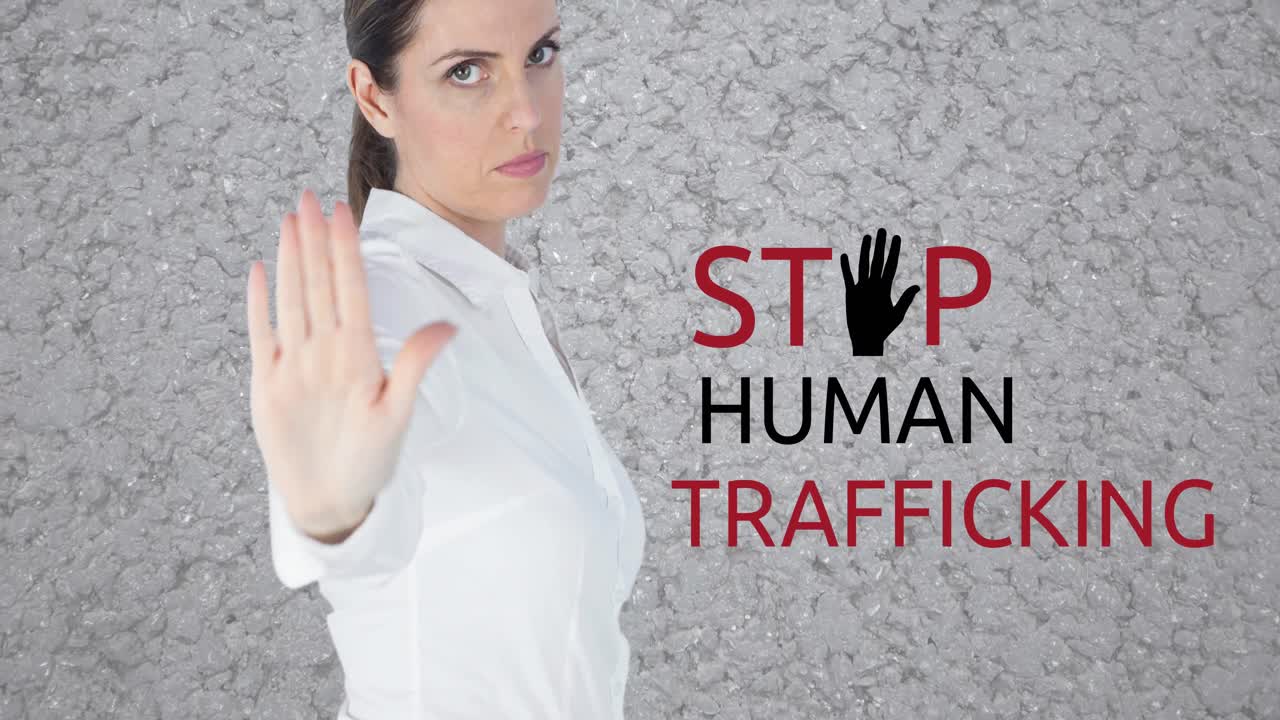 Animation of stop human trafficking text over caucasian woman with stop gesture