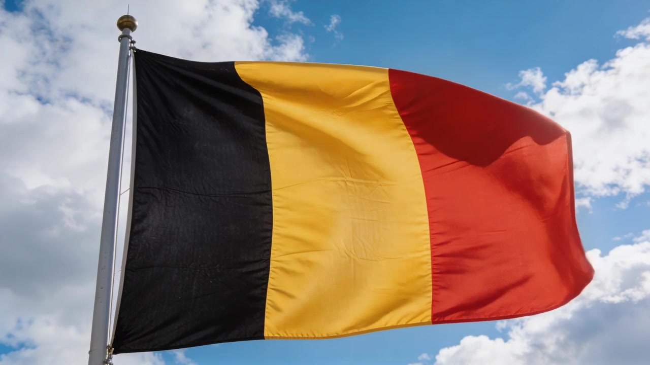 Vento impetuoso che fa sventolare una bandiera tricolore verticale su un'asta contro un cielo parzialmente nuvoloso, con drizza.