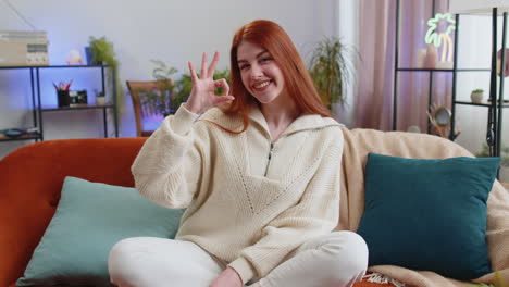 happy cheerful young woman looking approvingly at camera showing ok gesture positive like sign