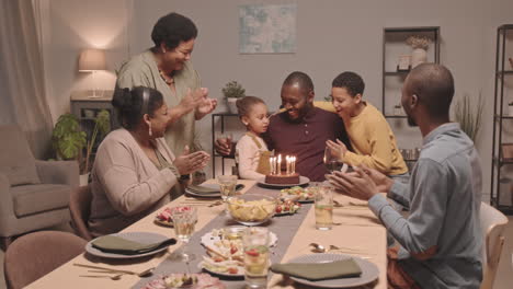 la familia celebra el cumpleaños con pastel y velas.