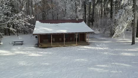 cottage at entrance reveal forest, winter scene, rising, pull back aerial