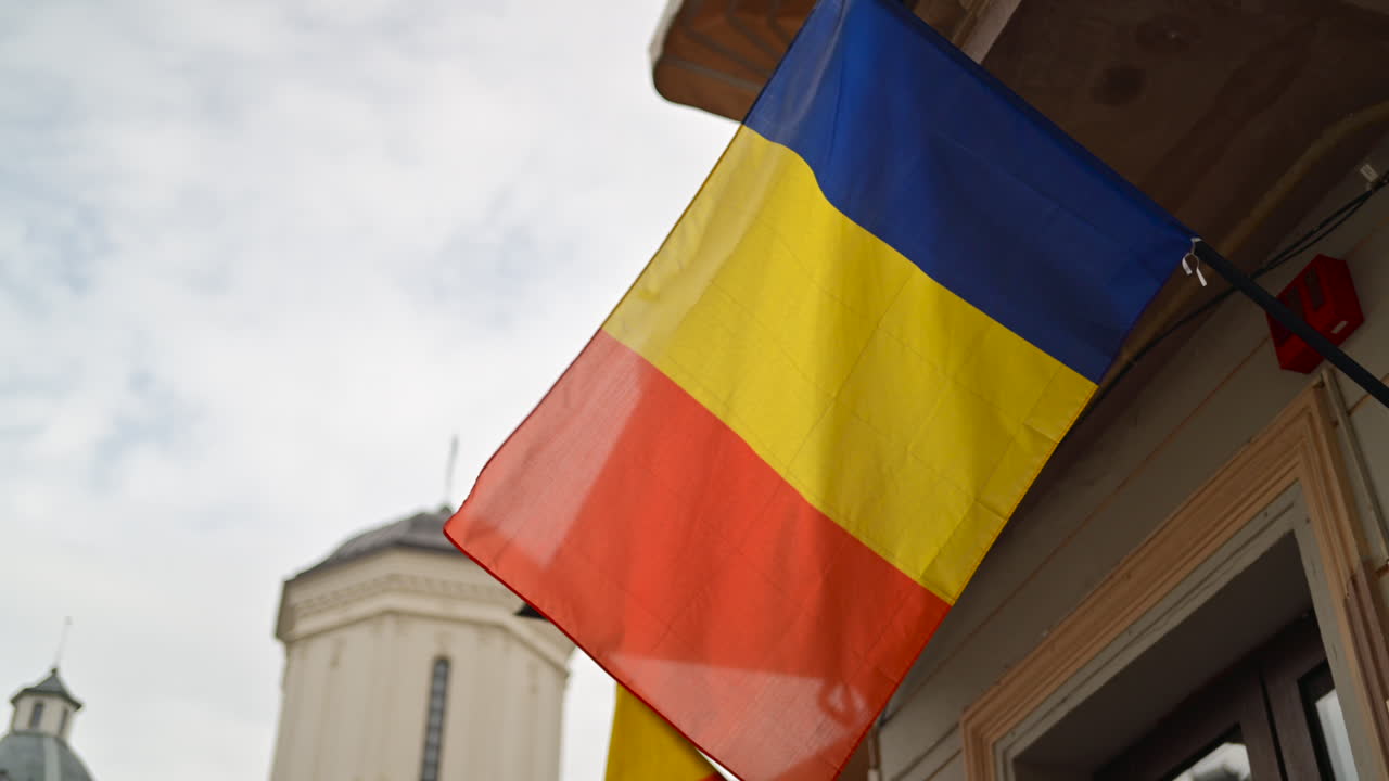 The Romanian flag waving on a building in the Old Town of Bucharest