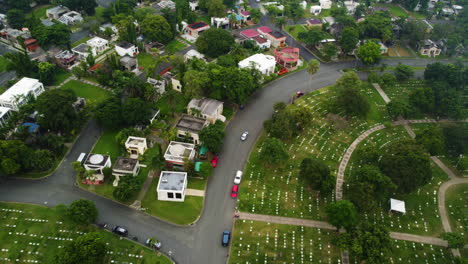drone tracking a car driving in middle of homes and graves, in parañaque, manila