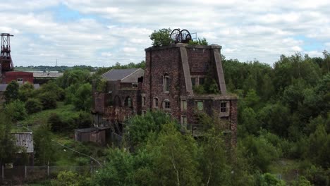 Abandonado-Viejo-Cubierto-De-Mina-De-Carbón-Industrial-Oxidación-Hoyo-Rueda-Edificios-Vista-Aérea-Aumento-Inclinar-Hacia-Abajo